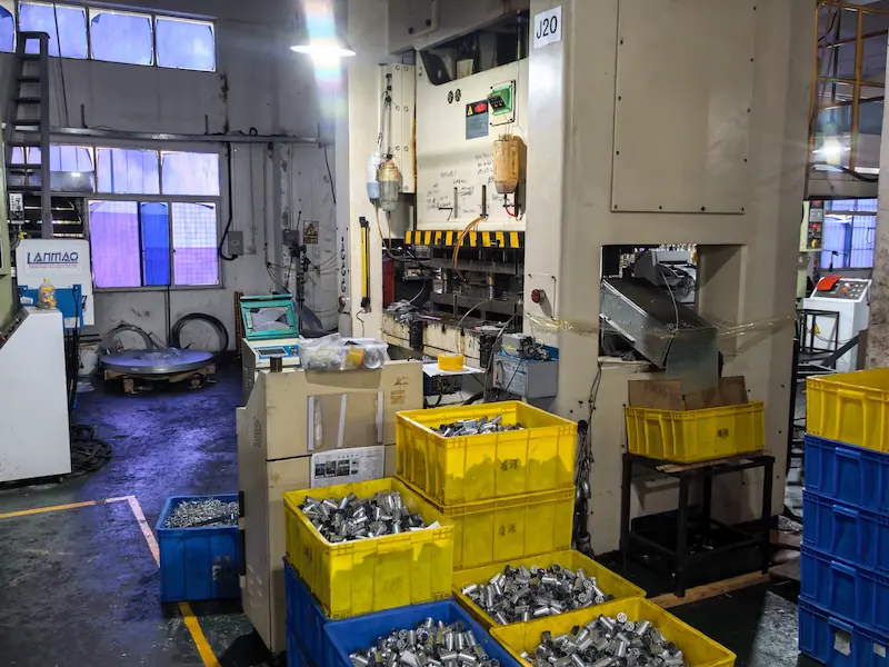 Thousands of identical precision deep drawn metal parts showcasing high volume production efficiency and seamless construction.