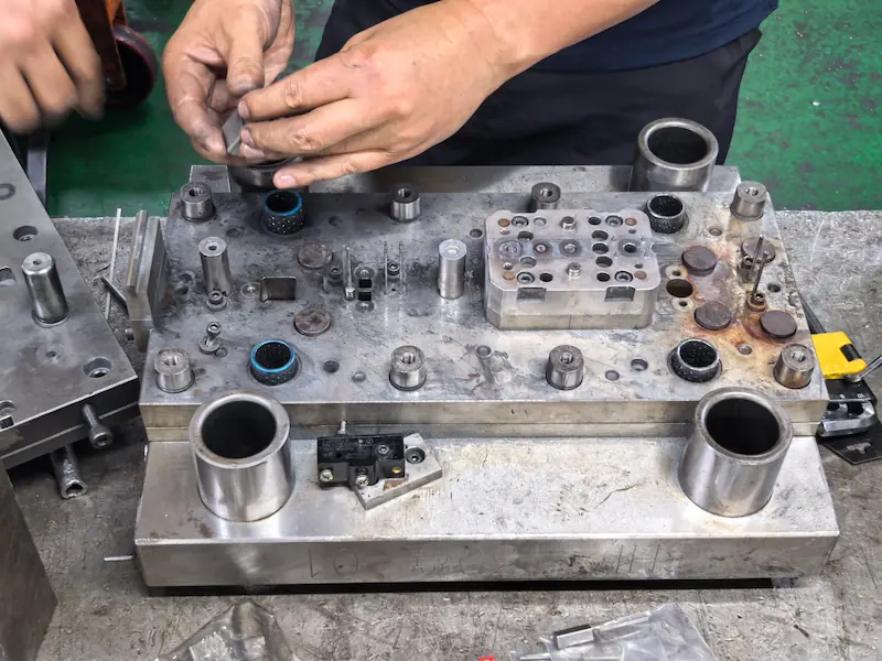 Engineers conducting DFM analysis and designing custom precision dies for deep drawn metal stamping.