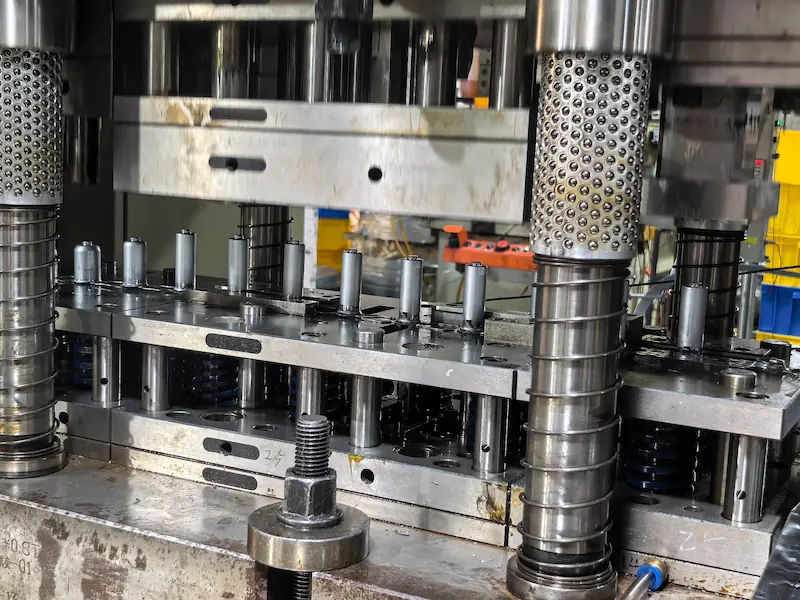 progressive die stamping process with metal strip feeding through multiple stations