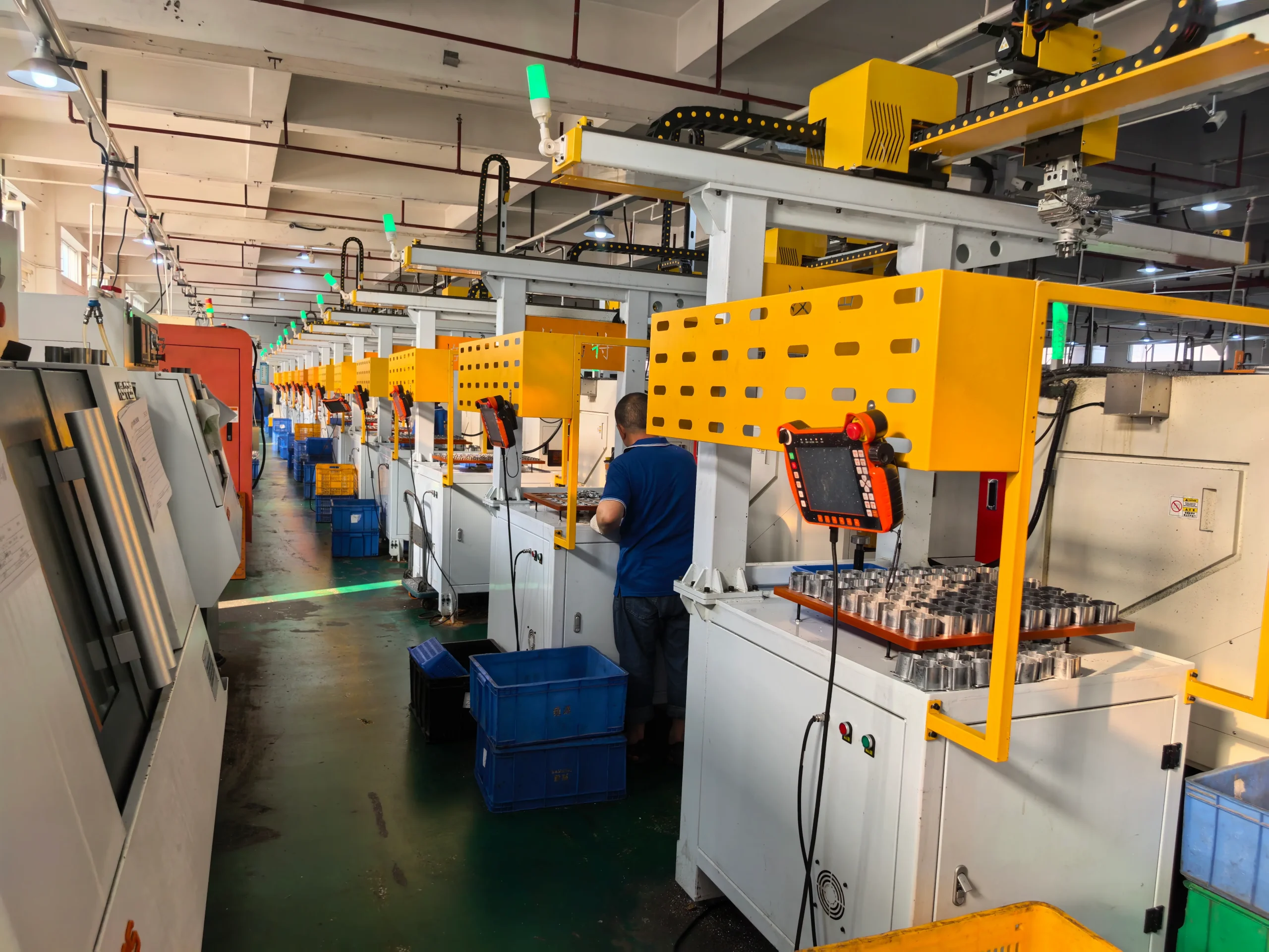 Clean workshop scene showing workers handling metal motor components in an organized production area